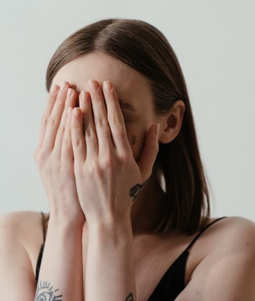 Woman holding her hands in front of her face